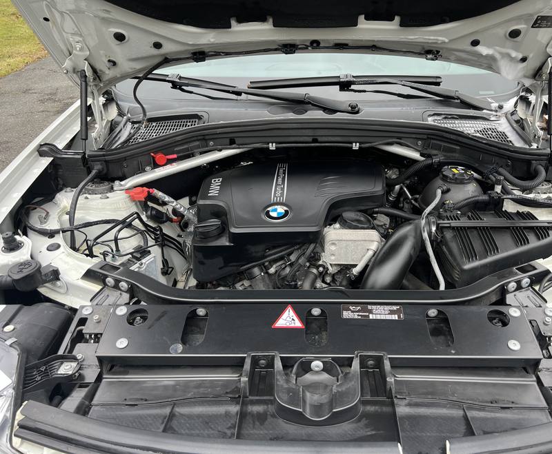 Mobile car detailing in Wesley Chapel, NC: BMW X3 engine bay with a clean engine cover and plastics