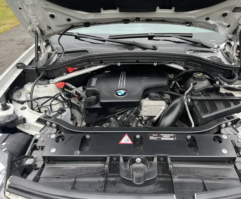 Mobile car detailing in Wesley Chapel, NC: BMW X3 engine bay with a clean engine cover and plastics