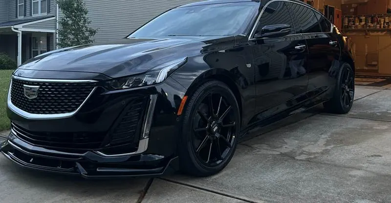 Black Cadillac CT5 with deep, reflective paint parked in a driveway
