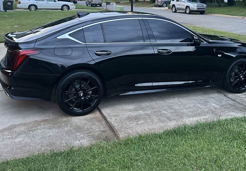 Car window tint in Charlotte, NC: Side profile of a black Cadillac CT5 sedan with dark tinted windows