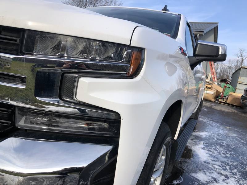 Mobile car detailing in Mint Hill, NC: Front of a white Chevy Silverado Z71 with glossy paint and chrome grille after a wash