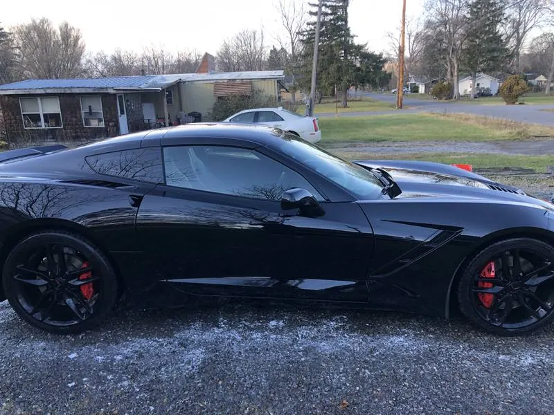 Premium mobile car detailing in Raleigh, NC: Side profile of a black C7 Corvette Stingray with mirror-like paint reflections after a detail