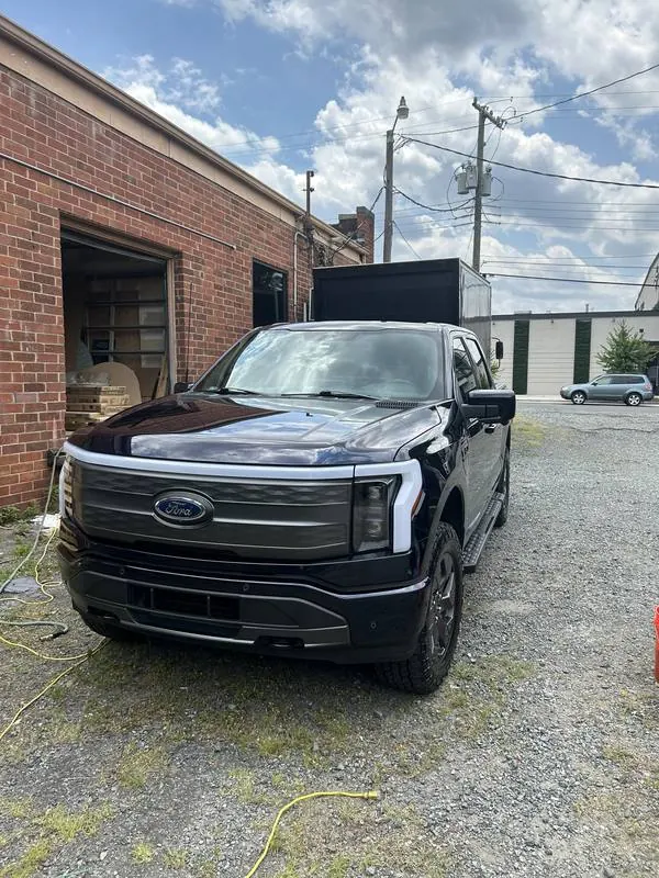 Mobile car detailing in Weddington, NC: Front of a dark blue Ford F-150 Lightning with glossy paint after a wash