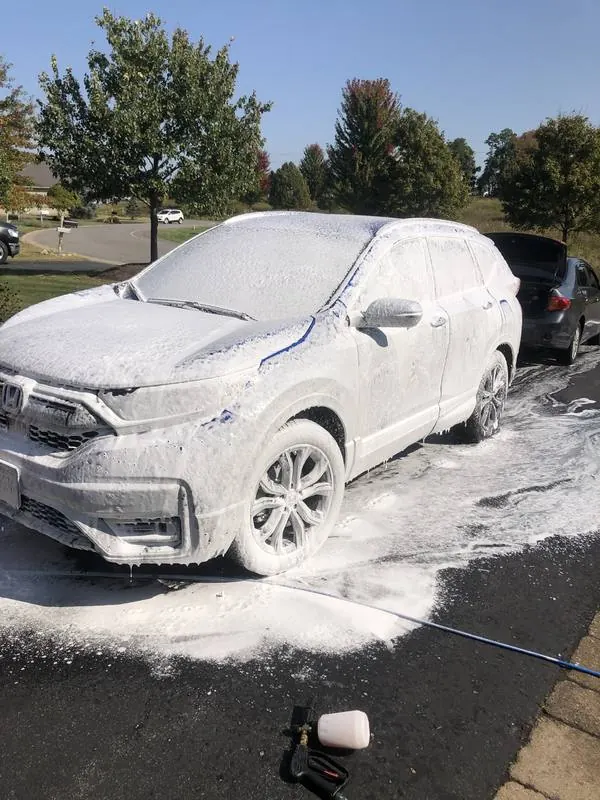 White Honda CR-V covered in foam during a mobile hand wash in a Charlotte driveway