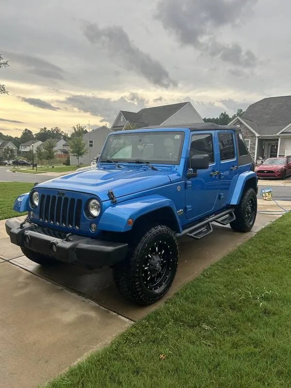 Mobile car detailing in Waxhaw, NC: Blue Jeep Wrangler Unlimited with black wheels and shined tires after a wash